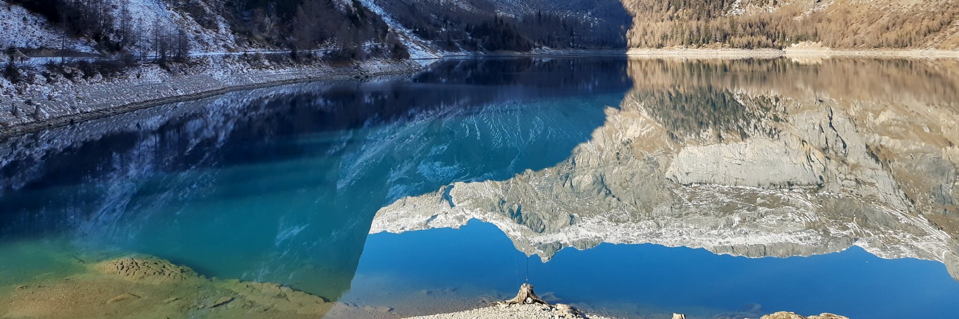 Lac alpin reflétant des sommets enneigés